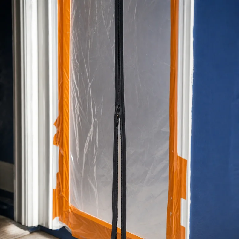 Sealed containment doorway with zipper access and taped edges to prevent air leakage